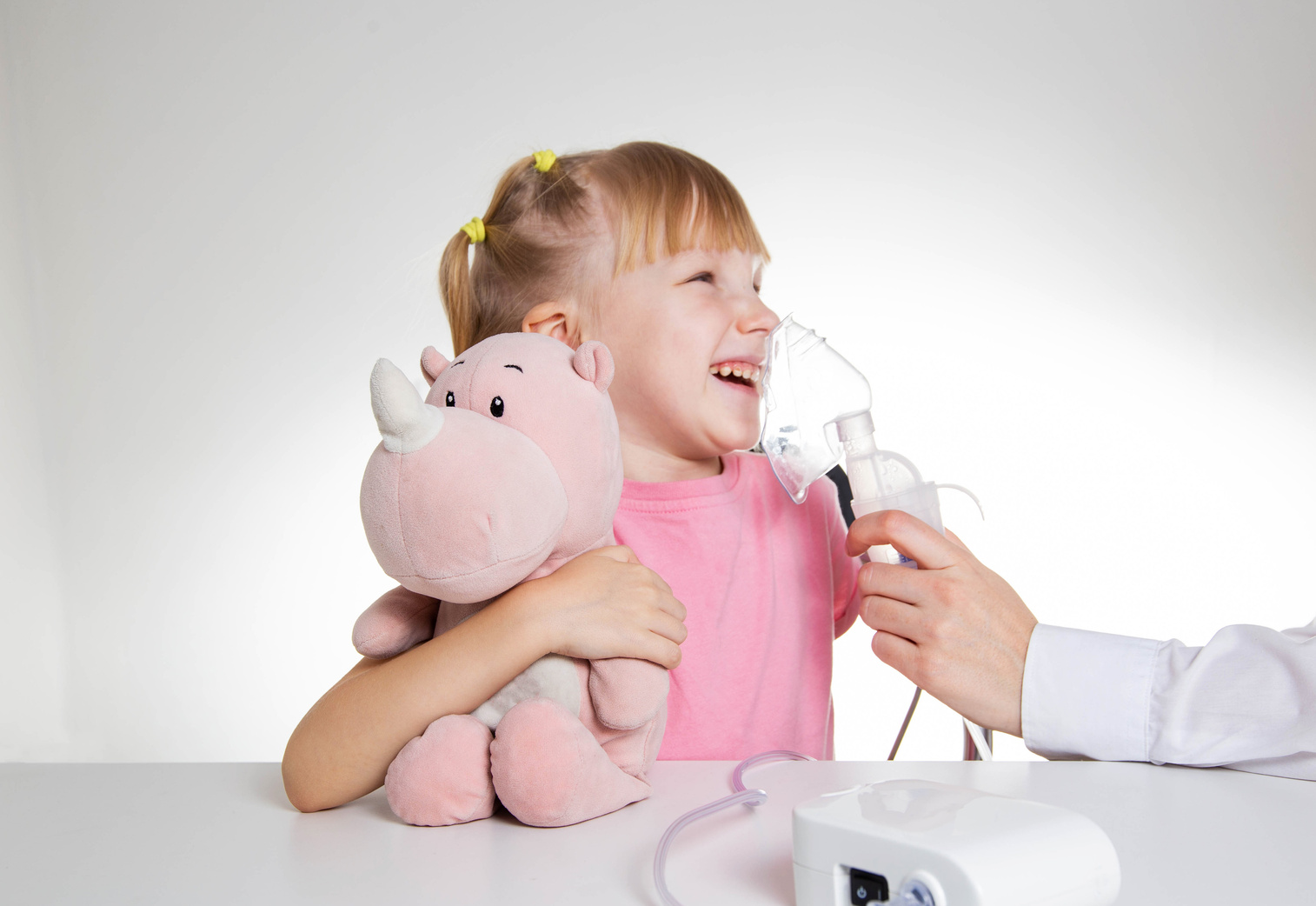 A 5-year-old girl breathes into an inhaler to dilute sputum in case of lung diseases. Treatment of cough in children. Nebulizer
